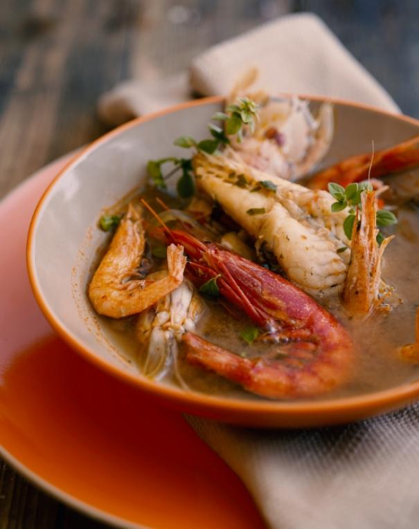 Zuppa di pesce calda, con gamberi e erbe aromatiche, profumo di mare e sapore intenso.