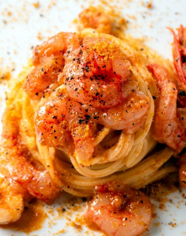 Spaghetti avvolti da succulenti gamberi, cosparsi di pepe e briciole dorate, invitano al gusto.