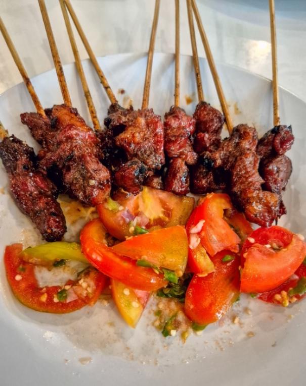 Spiedini di carne grigliata con pomodori freschi, un'esplosione di sapori succulenti e vivaci.