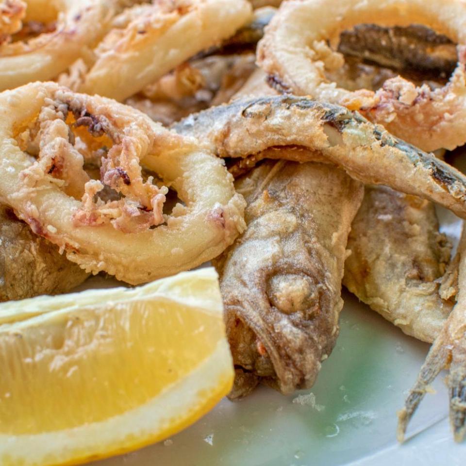 Frittura di pesce croccante e anelli di calamari con spicchio di limone.